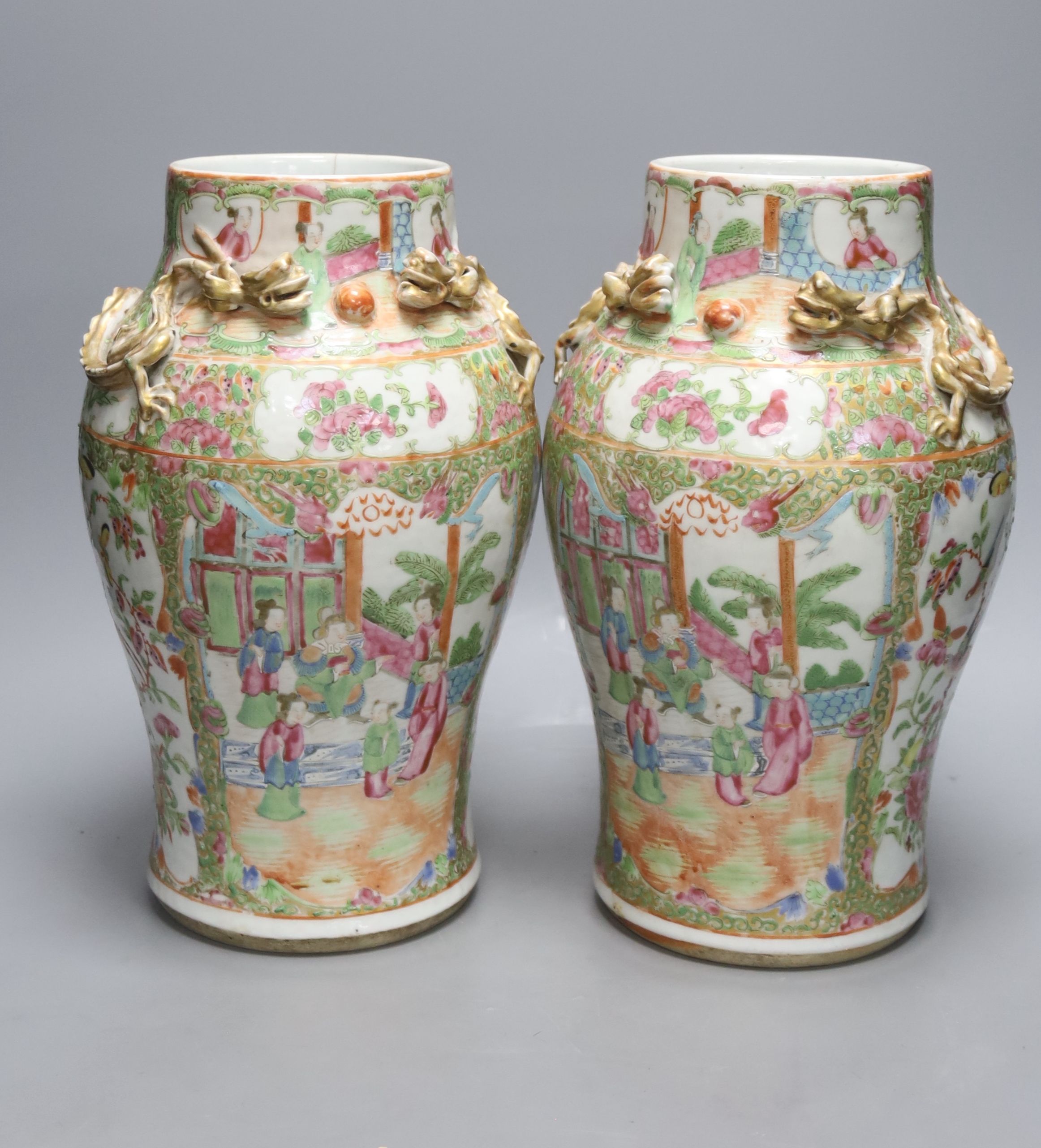 A pair of 19th century Chinese famille rose vases, height 30.5cm and a similar larger vase, 37.5cm (3)